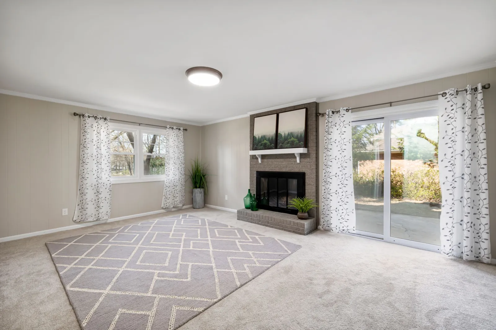 Carpeted family room with a fireplace and sliding patio door