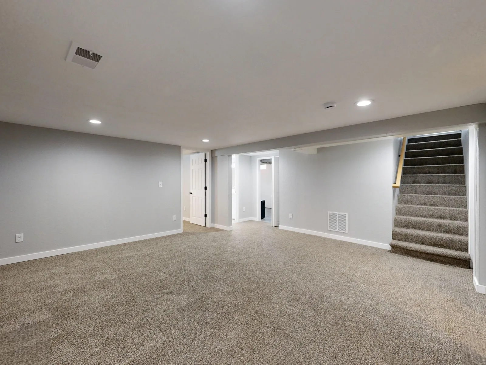 Beige carpet installed through a finished basement with stairs