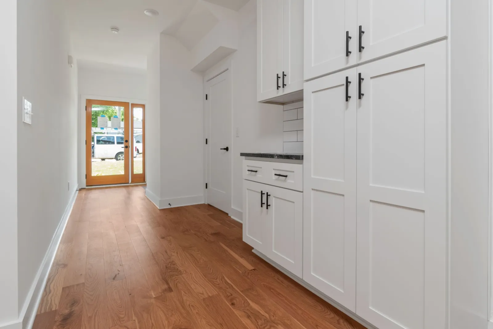 Solid hardwood flooring in a bright white kitchen