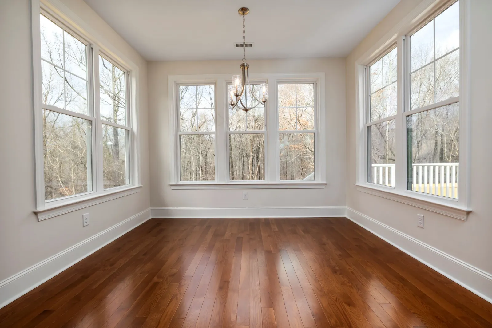 Prefinished wood flooring in a spacious room with big windows