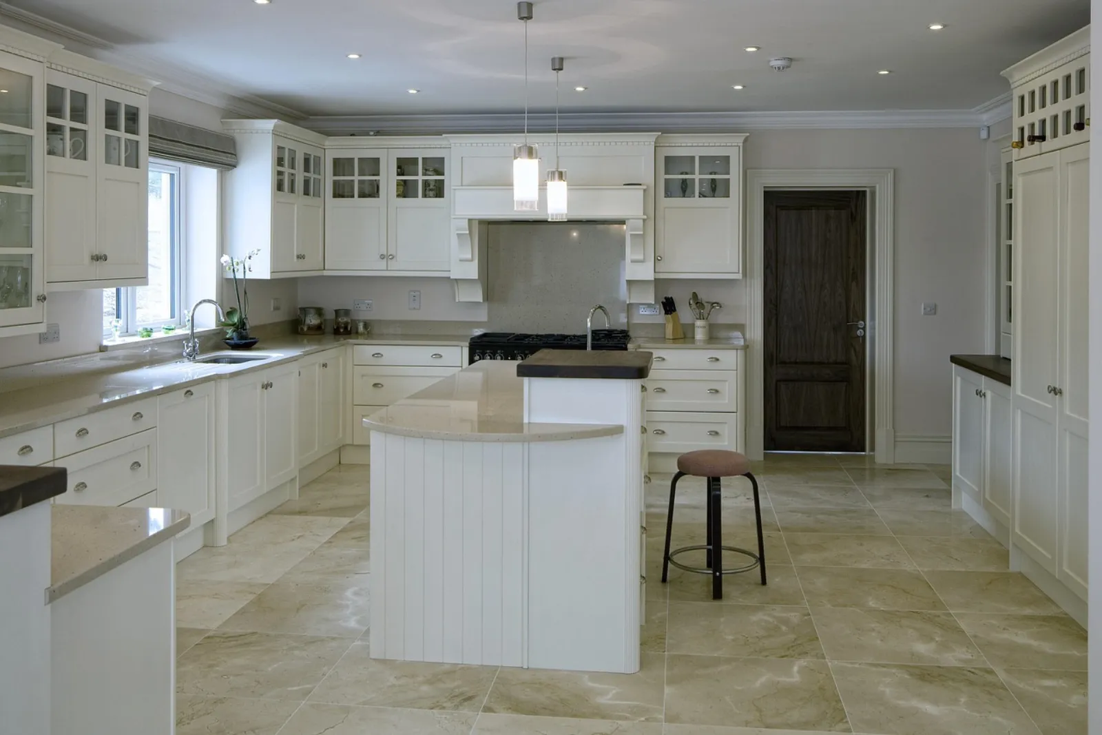 Stone-look tile flooring in a bright white kitchen with an island